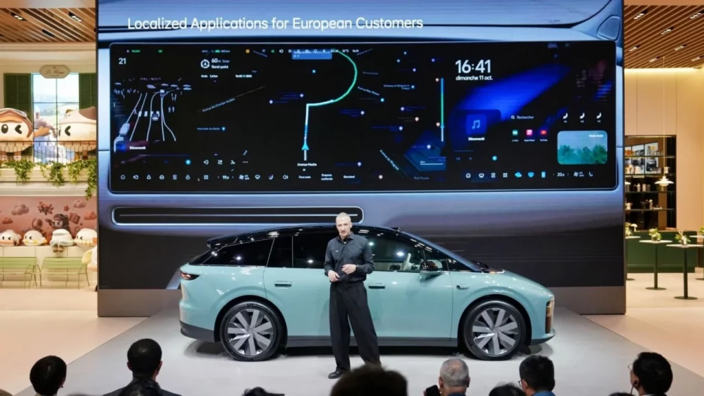 Prezenter omówi system multimedialny Li Auto L6 widoczny na wielkim ekranie za nim