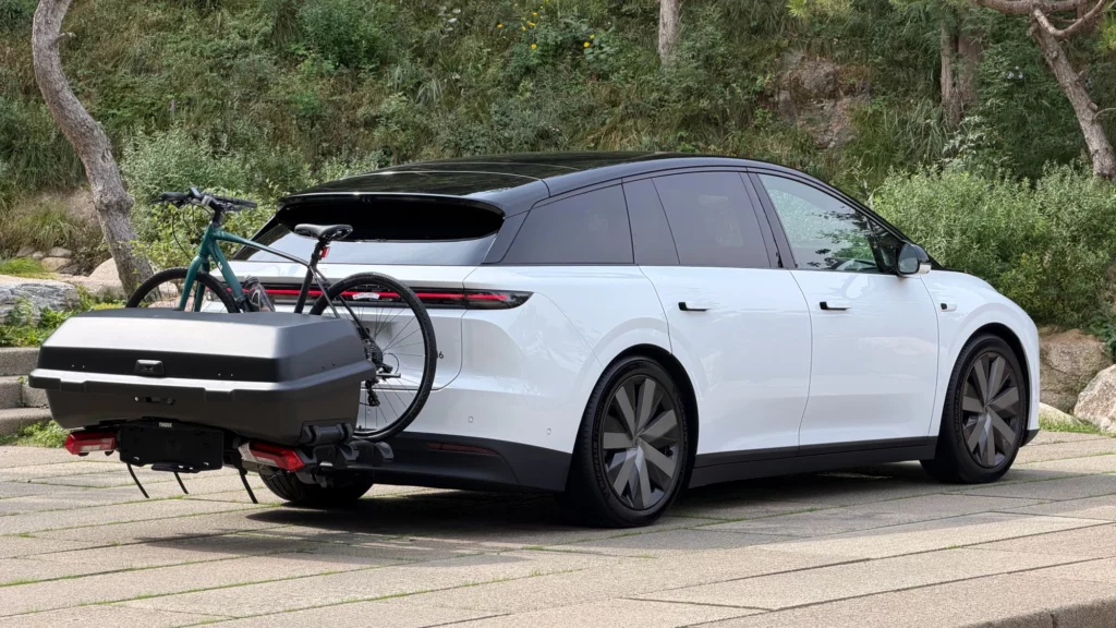 Biały Li Auto L6 zaparkowany tyłem z zamontowanym bagażnikiem rowerowym i boksem